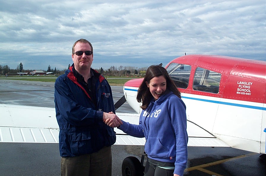 Naomi Jones receives congratulations from Transport Canada Inspector Peter Cox after the completion of Naomi's Class II Instructor Rating Flight Test. This achievement qualifies Naomi as a supervising Chief Flying Instructor. Langley Flying School.